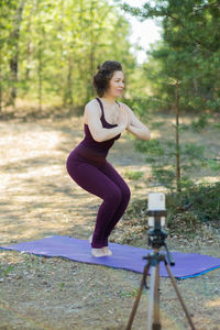 Side view of young woman exercising in park