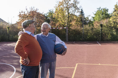 Two fit seniors having fun on a basketball field