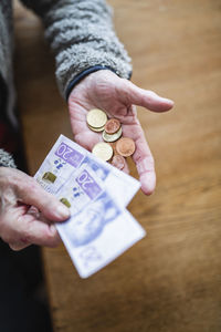 Hands holding banknotes and coins