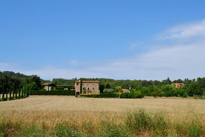 Houses on field against cloudy sky