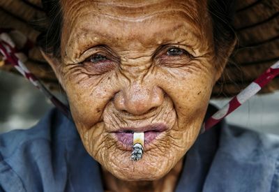 Close-up portrait of senior woman smoking cigarette