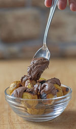 Close up of some roasted chestnuts and a spoon with cream of spreadable chocolate.