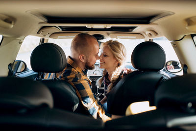 Rear view of people sitting in car