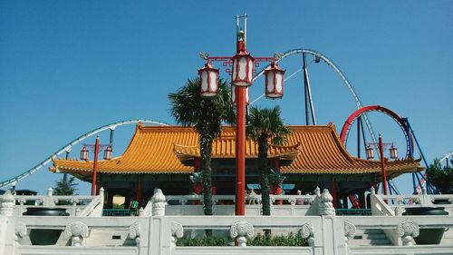 Low angle view of ferris wheel against blue sky