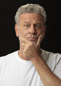 Portrait of man against black background