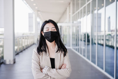 Young business woman wearing face mask in city. corona virus concept. eyes closed