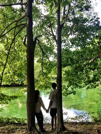 Rear view of man standing by lake