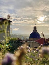 Temple by building against sky during sunset