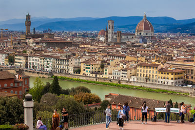 Tourists at the viewpoint of michelangelo square looking at the beautiful city of florence