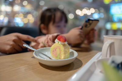 Midsection of woman holding ice cream on table