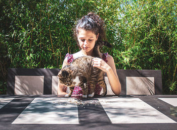 Portrait of woman with dog sitting outdoors