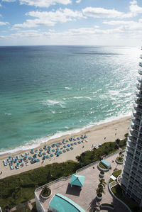 Aerial view of sea and cityscape against sky