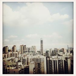 View of cityscape against cloudy sky