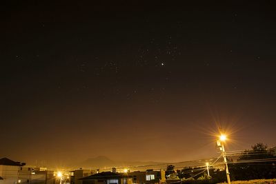 Illuminated city against sky at night