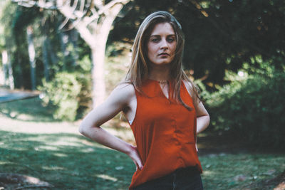 Portrait of woman with hands on hips standing at park