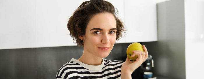 Portrait of young woman holding apple