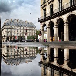 Buildings in city against cloudy sky