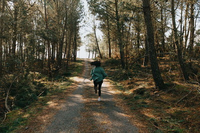 Rear view of woman walking in forest