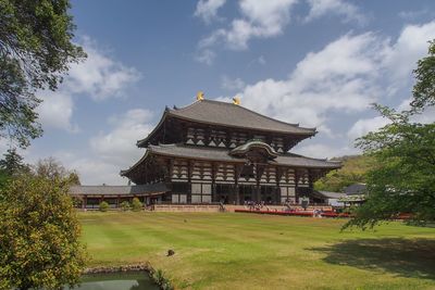 Temple by building against sky