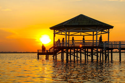 Silhouette pier on sea against sky during sunset