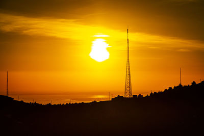 Silhouette of tower against sky during sunset