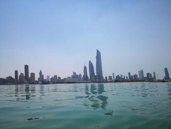 Sea and buildings against clear sky