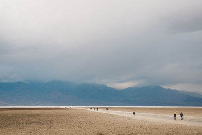 Scenic view of desert against cloudy sky