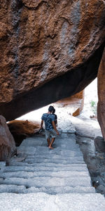 Rear view of woman walking on rock