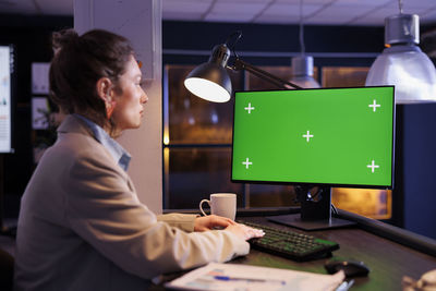 Side view of businesswoman using laptop at home