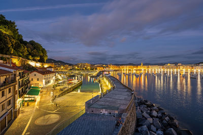 The port of san sebastian with the city in the back at night