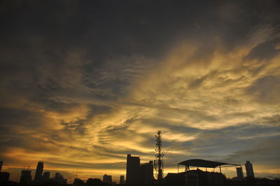 Low angle view of silhouette buildings against dramatic sky