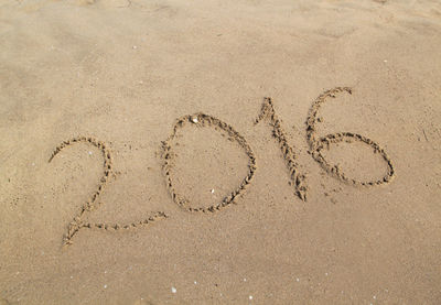 High angle view of text on sand at beach