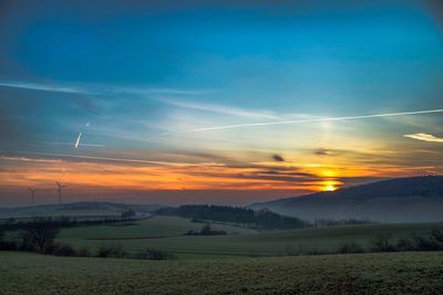 Scenic view of field against sky during sunset