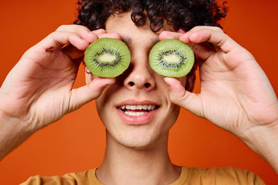 Portrait of smiling young woman holding fruits