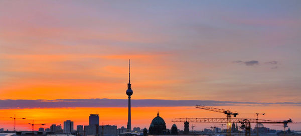 Silhouette of city against cloudy sky