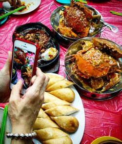 Close-up of hand holding food served on table