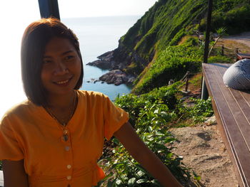 Portrait of smiling young woman by sea