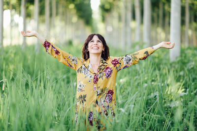 Portrait of smiling young woman standing on field