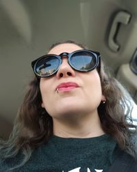 Woman wearing sunglasses while sitting in car