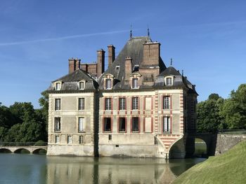 Arch bridge over river against buildings