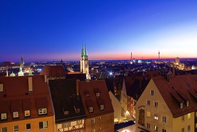 Church in illuminated city against sky