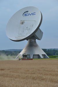 Information sign on field against sky