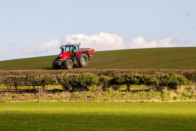 Tractor on agricultural field against sky