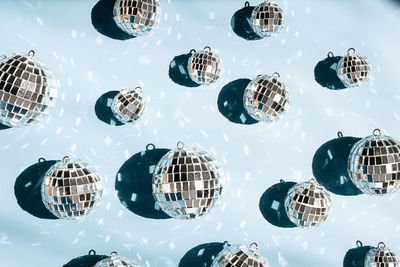 Shiny mirrored disco balls casting reflections and creating festive atmosphere.