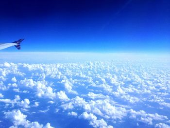 Cropped image of airplane flying over cloudscape