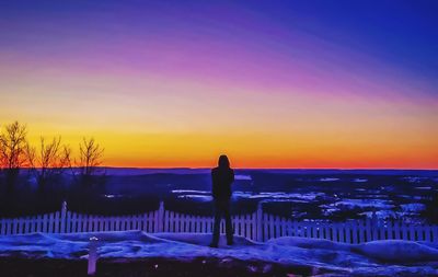 Silhouette woman standing on land during sunset