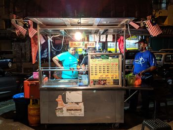 People working at market stall at night
