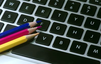 Blue, red and yellow drawing pencils on the keyboard