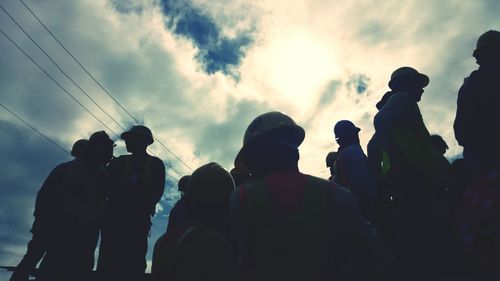 People against cloudy sky