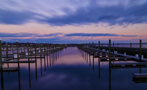 Pier on sea against sky at sunset